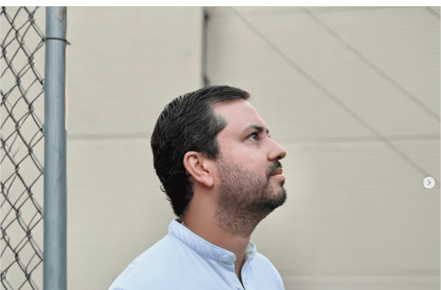Lucas Restrepo Jiménez de perfil, camisa clara, junto a una malla en Sabaneta, en el inicio de mejoramientos de vivienda.
